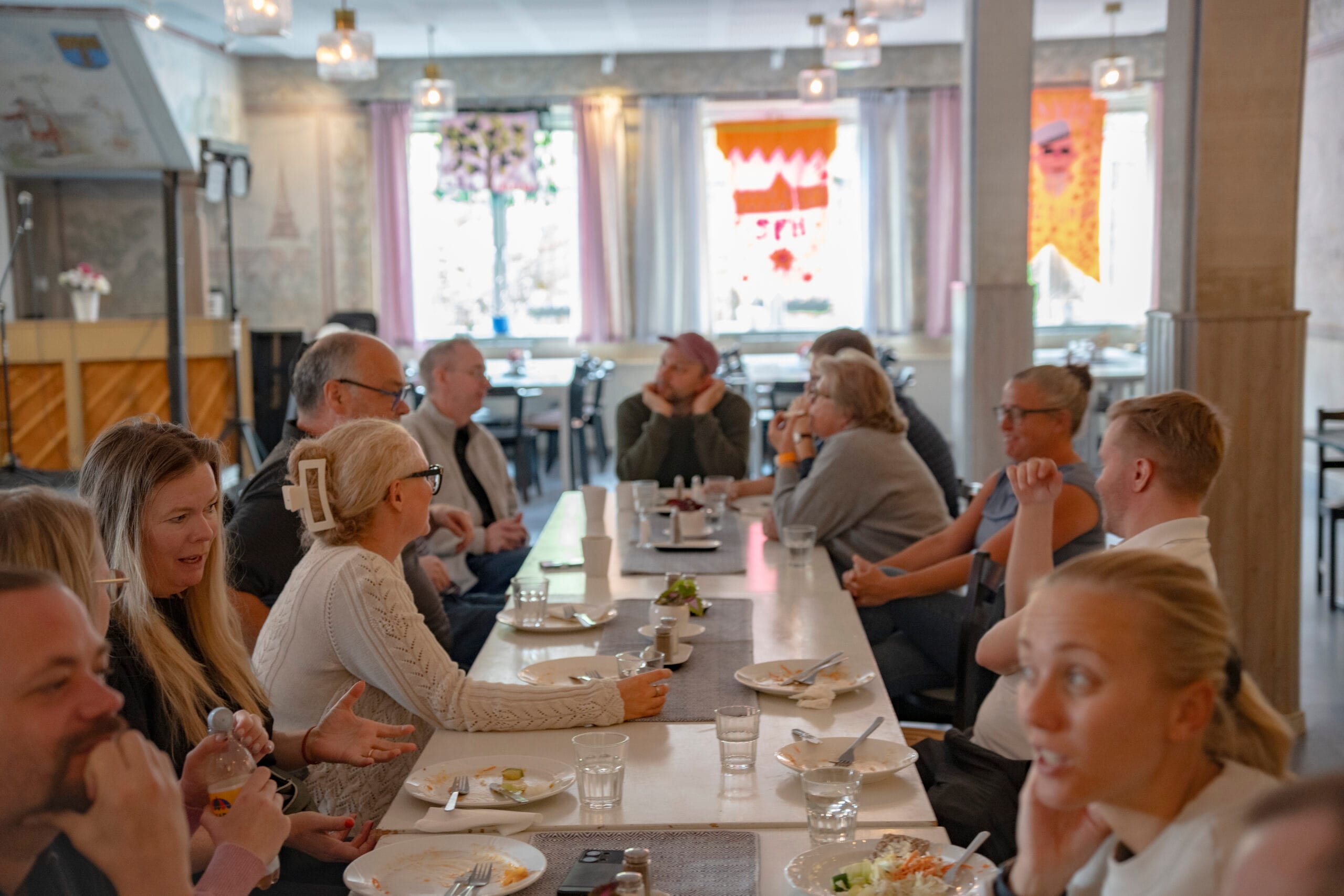 Personer samtalar efter måltid i inbjudande matsalsmiljö på Sigtuna folkhögskola.